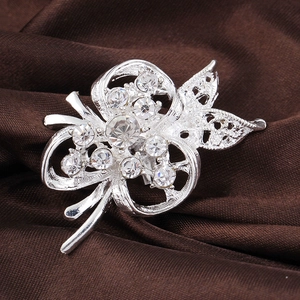 Broche fleur creuse argentée avec strass en cristal sur fond élégant en soie marron foncé