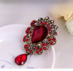 Macro shot of luxury red crystal brooch with pear-cut stone and bronze filigree detail