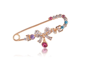 Détail de la broche épingle dorée avec strass colorés, lettres LOVE et pendentif rose