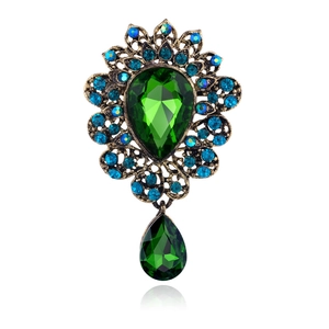 Luxurious vintage green crystal brooch with bronze floral frame and drop pendant