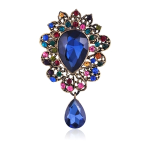 Luxury vintage crystal brooch with blue teardrop stone and multi-color gems on bronze base