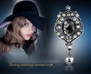 Detailed macro of vintage silver brooch with black crystals and a grey pearl pendant
