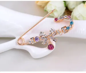 Détail macro d'une broche en cristal coloré avec lettrage LOVE et un design de nœud