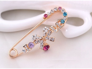 Gros plan sur la broche LOVE avec strass colorés et nœud papillon rose élégant