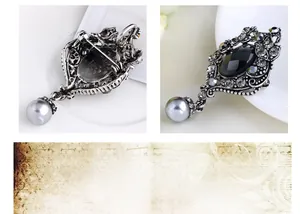 Detail view of vintage silver brooch with black gemstone, rhinestones and grey pearl