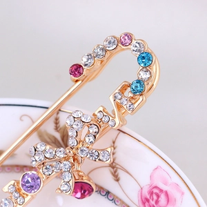 Broche dorée avec strass colorés, lettres LOVE et un design de nœud élégant