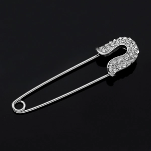Elegant silver-toned safety pin brooch with sparkling white rhinestones for modern outfits