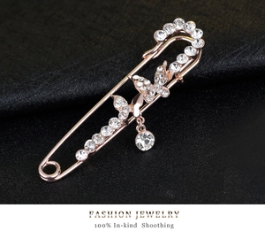 Macro detail of rose gold butterfly brooch pin with sparkling rhinestone crystal drops