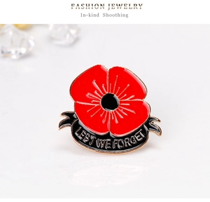 Detailed close-up of poppy brooch with red enamel and Lest We Forget engraving