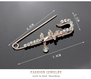 Detailed view of luxury rose gold butterfly brooch with rhinestones and a crystal pendant