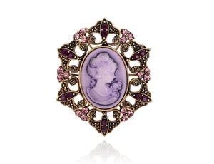 Macro shot of vintage cameo brooch featuring purple silhouette and crystal-set metal frame
