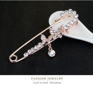Detailed view of luxury rose gold butterfly brooch with rhinestones on white ceramic