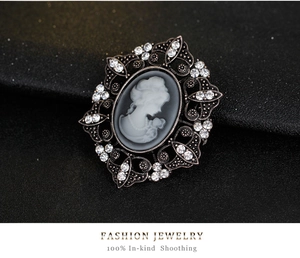 Detailed close-up of vintage cameo brooch with rhinestone-encrusted hollow floral frame
