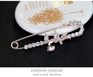 Detail of rose gold butterfly pin with full rhinestones on a black background