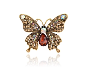 Detailed close-up of butterfly brooch with champagne crystals and amber teardrop stone