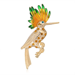 Macro detail of bird brooch with colorful enamel wings and amber crystal inlay