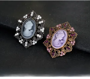 Detail of vintage cameo brooches with intricate filigree and colorful rhinestones