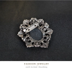 Detail of vintage silver flower brooch back featuring a secure safety pin fastener