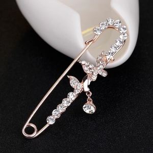 Luxury rose gold butterfly brooch pin with sparkling diamonds on a black textured background