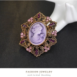 Macro view of vintage cameo brooch with purple lady relief and pink rhinestones