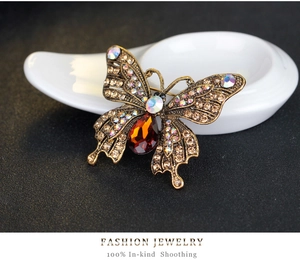 Detailed macro view of vintage butterfly brooch with colorful crystals and amber stone