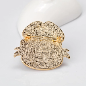 Back view of gold poppy brooch showing textured matte finish and secure pin clasp