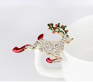 Détail d'une broche de renne de Noël avec cristaux blancs et bois en émail vert brillant