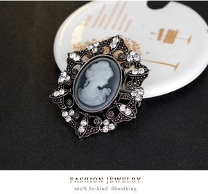 Macro detail of vintage lady portrait brooch with ornate silver frame and crystals
