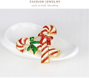 Detailed view of candy cane brooch with red and white enamel finish and green bow detail
