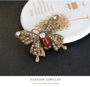 Macro detail of a vintage butterfly brooch with amber stone and colorful rhinestones