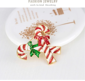 Detailed view of crossed Christmas candy cane brooches with festive red and green bows