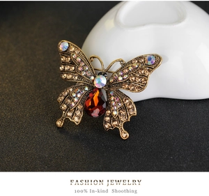 Detail of a vintage butterfly brooch with crystal wings and a teardrop-shaped brown gem