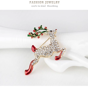 Détail d'une broche de renne de Noël avec strass blancs et bois en émail vert brillant