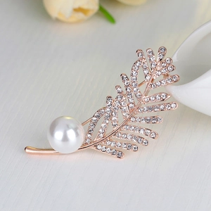 Élégante broche plume en or rose avec des strass étincelants et une grande perle blanche