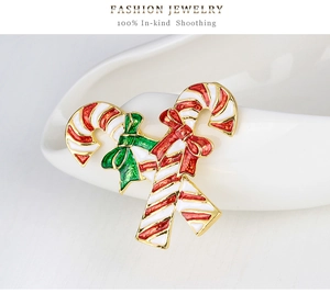 Detail view of red and white candy cane brooch with festive green and red bows
