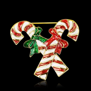 Christmas candy cane brooch with red and green enamel bows on a black background