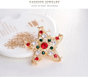 Makro-Detail der goldenen Sternbrosche mit bunten Kristallen und Vintage-Handwerk