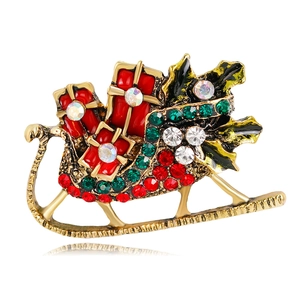Detail of vintage gold Christmas sleigh brooch with colorful rhinestones and enamel finish