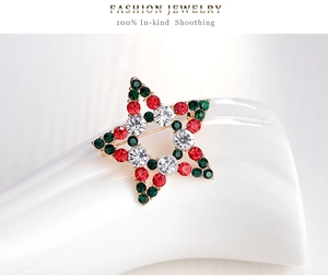 Detailed close-up of a Christmas star brooch with red and green rhinestones