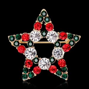 Star-shaped Christmas brooch with red and green rhinestones on a gold metal frame