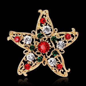 Funkelnde goldene Sternbrosche mit roten und grünen Strasssteinen auf schwarzem Grund