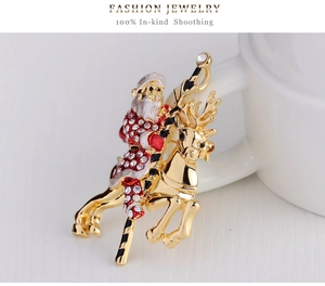 Detailed close-up of a Santa Claus riding a golden reindeer brooch with rhinestones