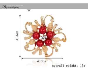 Detailed view of 4.3cm golden floral brooch with red pearls and central white crystal