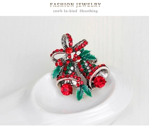 Detail der Weihnachtsglocken-Brosche mit roter Strass-Schleife und grünen Stechpalmen