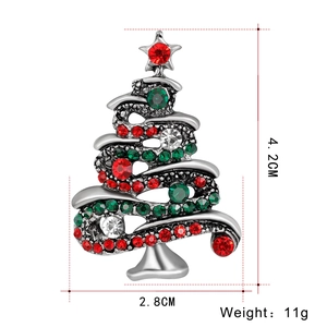 Macro view of Christmas tree brooch with red, green, and white rhinestones on silver alloy