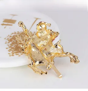 Close-up of golden Santa Claus and reindeer brooch with detailed metallic texture