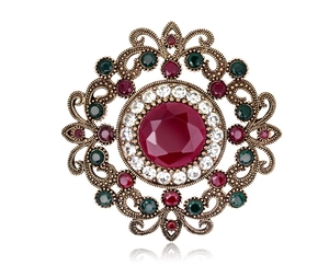 Macro shot of retro hollow brooch with red center crystal and sparkling rhinestones
