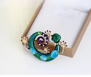 Détail de broche lézard avec émail vert, pierres bleues et strass brillants argentés
