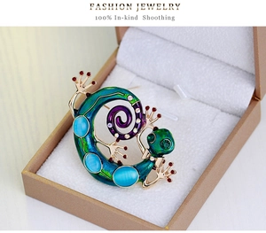 Détail de broche caméléon en émail sarcelle, pierres œil-de-chat et cristaux brillants