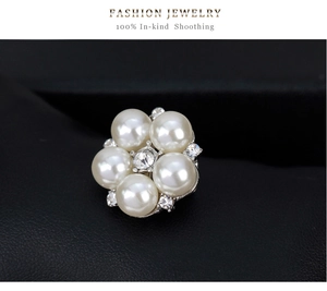 Macro shot of pearl flower brooch with central zircon and small crystals on leather